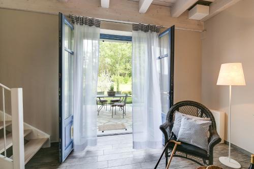 a living room with a door leading to a patio at Cascina Arcangelo Raffaele in Verduno