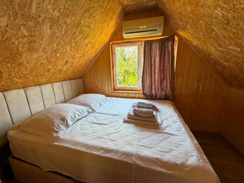 a bed in a small room with a window at Rezo's Ranch Cottage in Samtredia