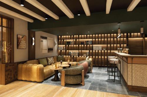 a restaurant with couches and tables and a bar at Hôtel de l'Europe by HappyCulture in Strasbourg