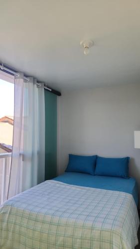 a bedroom with a blue bed with a window at Casa Casal Itapoá in Itapoa