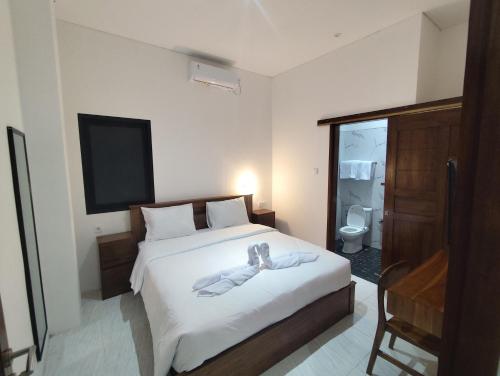 a bedroom with a bed with a robe on it at Moonrise Rooms in Uluwatu