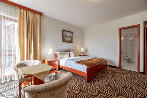 a hotel room with a bed and a chair at Sándor Hotel in Pécs