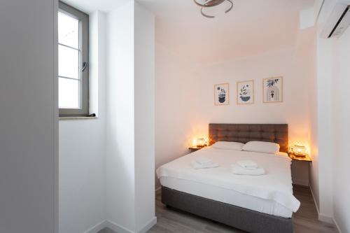 a bedroom with a white bed with two hats on it at Kargı Suites Datça in Datca