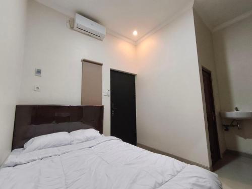 a bedroom with a large bed and a sink at Teras Watu Tegal in Tegal