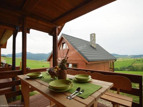 a wooden table with green bowls on top of a house at Domki Czterech Braci in Grywałd