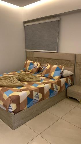 a bedroom with a bed with a comforter and pillows at بورتو السخنه الاهرامات in Ain Sokhna