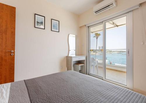 a bedroom with a bed and a view of the ocean at Lighthouse Seafront Panorama - Kato Paphos Central in Paphos