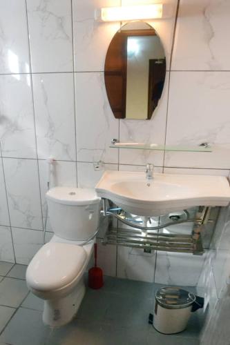a bathroom with a toilet and a sink at ALVI SEVEN Hotel in Douala
