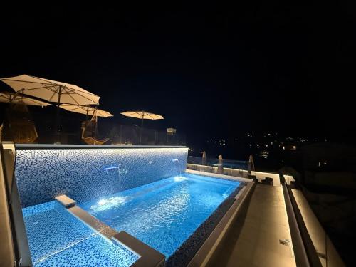 a swimming pool on top of a building at night at Apartments Pericic LUX in Sutomore