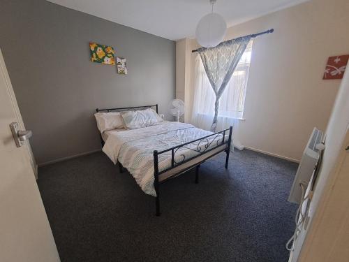 a bedroom with a bed and a window at E Gardens Apartment in Nottingham