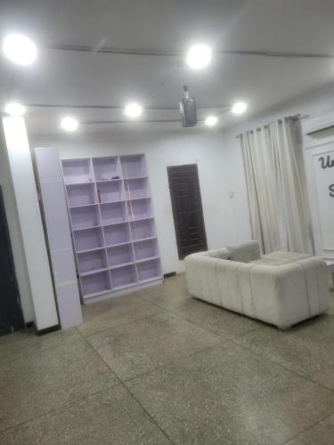 a living room with a white couch in a room at Mohe's place in Ilorin