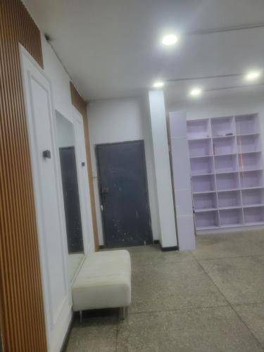 an empty room with a white chair and shelves at Mohe's place in Ilorin