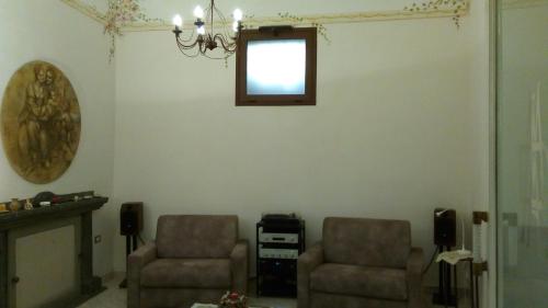 Una sala de estar con dos sillas y una ventana. en B&B Le Volte, en Sarno