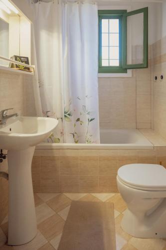 a bathroom with a sink and a toilet and a tub at Bellevue Apartments in Sitia