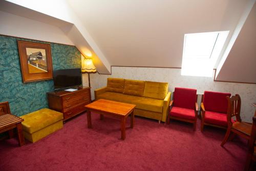 a living room with a couch and a table at Hotel Paříž in Jičín