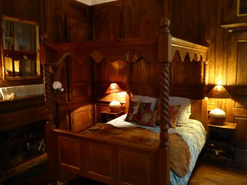 a bedroom with a canopy bed with wooden walls at Appartement des Remparts in Dinan