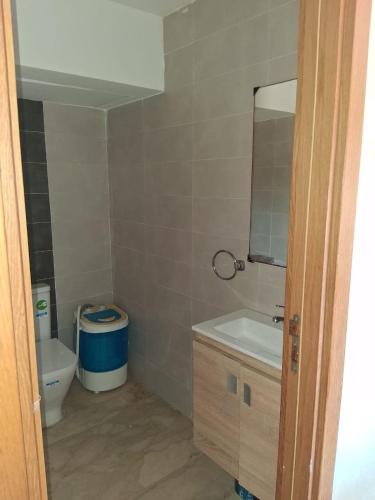 a bathroom with a toilet and a sink and a mirror at Modern Apartment with Pool & Sea View in Casablanca