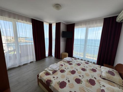 a bedroom with a bed and large windows at стаи за гости Гергана in Tsarevo