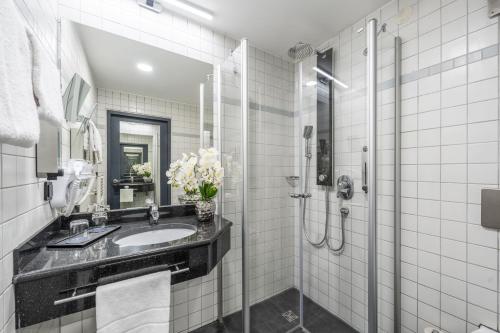 a bathroom with a sink and a shower at PLAZA INN Stuttgart-Ditzingen in Ditzingen