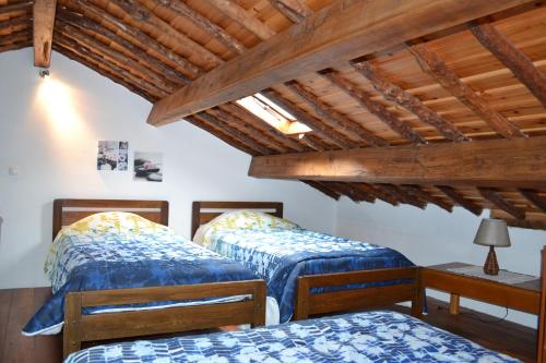two beds in a room with wooden ceilings at Casa Doce Mar in Feteira