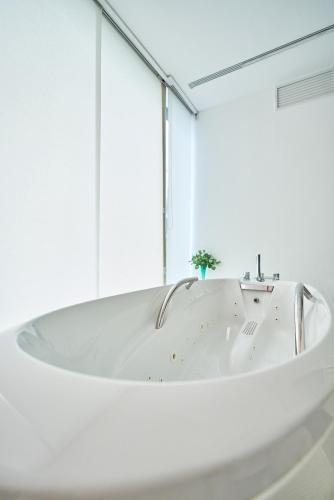 a white bath tub in a room with a window at Spa Sanatorium Dr Peták in Františkovy Lázně