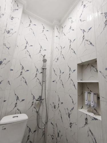 a bathroom with a toilet and a shower at Teras Watu Tegal in Tegal