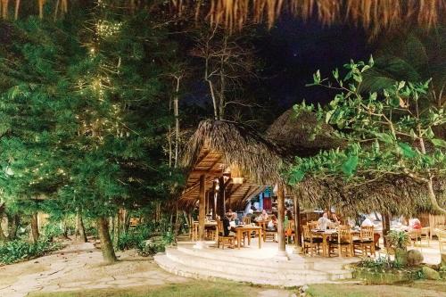 a restaurant with people sitting at tables in a forest at Natura Cabana Boutique Hotel & SPA in Cabarete