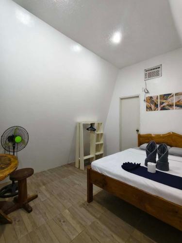 a bedroom with a bed and a table and a chair at travis homestay in Siquijor