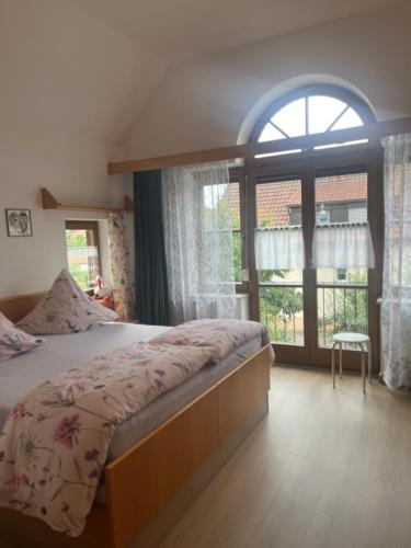 a bedroom with a bed and a large window at Gästehaus Jutta / Pension Link in Fladungen