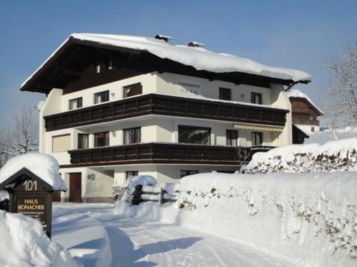a house covered in snow in front at Ferienwohnung Ronacher in Abtenau