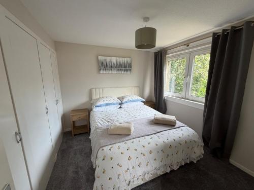 a bedroom with a bed with two pillows on it at The Narrows - Macaulay Letting in Rhu