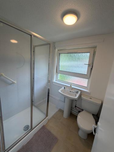 a bathroom with a shower and a toilet and a sink at The Narrows - Macaulay Letting in Rhu