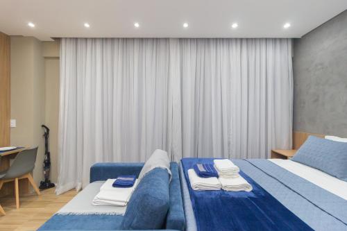 a bedroom with a blue bed with towels on it at The CityPlex | Apartamentos Prime no Centro de Osasco in Osasco