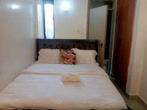 a bed with a white sheets and a robe on it at Tsavo in Nairobi