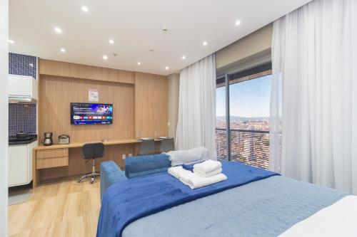 a bedroom with a blue bed and a television at The CityPlex | Apartamentos Prime no Centro de Osasco in Osasco
