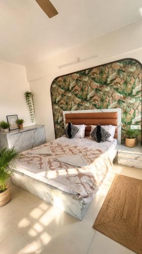 a bedroom with a large bed with a large headboard at LuxeBnb - The Olive Maple Room in Pune