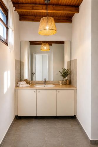 a bathroom with a sink and a large mirror at Lalloudes Hotel Mani in Éxo Nímfion