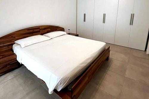 a bedroom with a large bed with white sheets at Villetta Pima in Garda