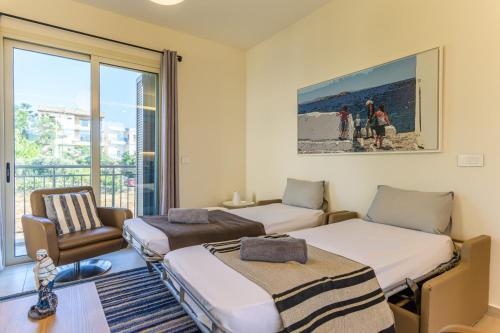 ein Zimmer mit zwei Betten, einem Stuhl und einem Fenster in der Unterkunft Papiro Apart Hotel in Byblos