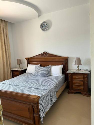 a bedroom with a wooden bed and two night stands at Dar zgolli in Kelibia