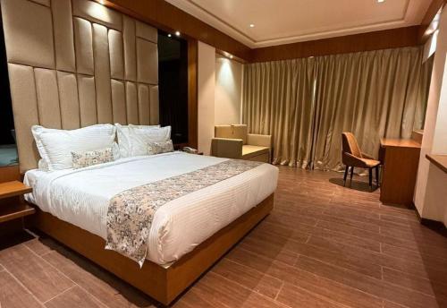 a bedroom with a large bed in a hotel room at Centre Point Amravati in Amrāvati