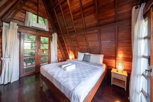 a bedroom with a bed in a wooden room at Medukuh Point Hill in Karangasem