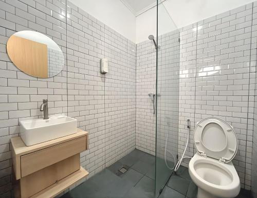 a bathroom with a toilet and a sink and a mirror at Tamashii Boutique Hotel in Bandung