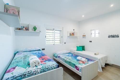 two beds in a room with white walls at Cubo's Maipa Rural House in Loja
