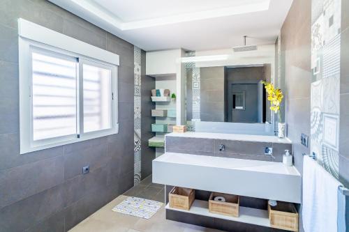 a bathroom with a sink and a mirror at Cubo's Maipa Rural House in Loja