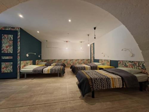 a room with four beds in a row at Pause ton sac in Condom