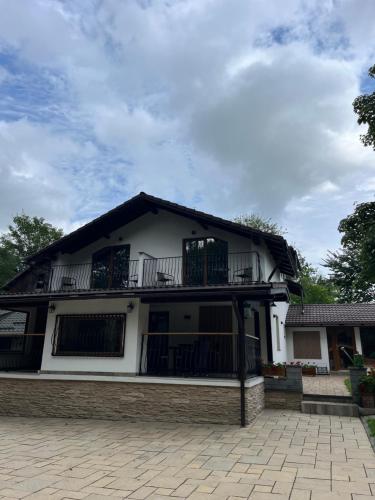 a white house with a balcony on top of it at Casa Carolianne in Bran
