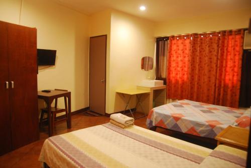 a hotel room with two beds and a table at Centro Mactan Suites in Mactan