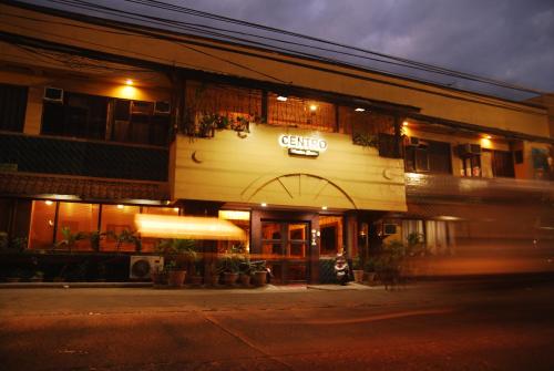 a building with a sign on the front of it at night at Centro Mactan Suites in Mactan