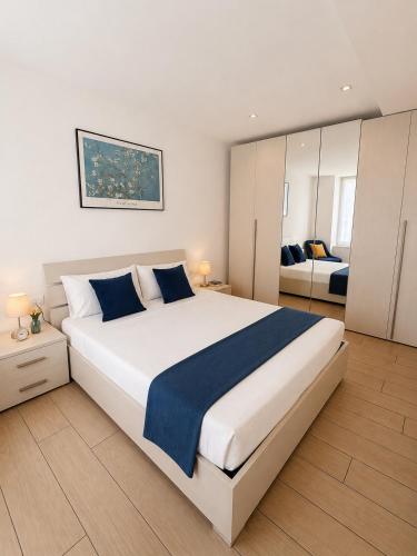 a bedroom with a large white bed with blue sheets at Luna Luxury Suite in Bergamo
